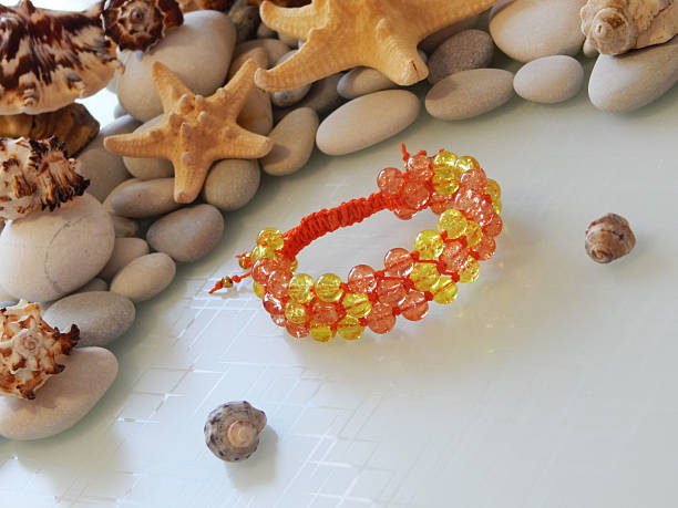 istock Orange bracelet and sea shells 2218901823