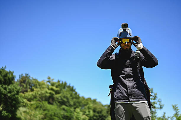 Paraglider adjusting his goggles before taking off, with a helmet and action camera