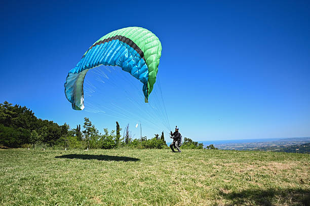 parachuter gliding in the sky over the mountains in winter