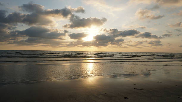 istock Golden sunset illuminating calm ocean waves on sandy beach 2218907168