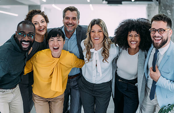 Excited coworkers embracing each other during a celebration in the office.