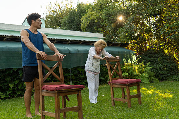 istock Senior woman doing physical therapy exercises with personal trainer in backyard 2218916780