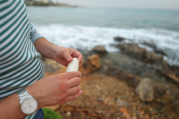 wrinkled hands of an elderly grandfather while holding some shells. High quality photo