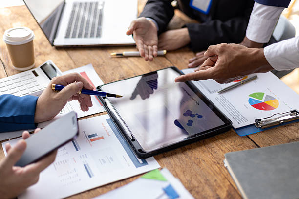 istock Business people analyzing financial data on digital tablet and laptop. Business team analyzing financial data on digital device in office, discussing strategy for growth and success. 2218920805