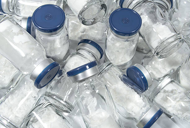 istock Glass vials with blue caps containing powdered medicine 2218921793