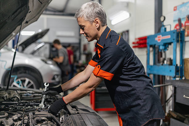 istock Female mechanic using wrench on car engine. 2218929001