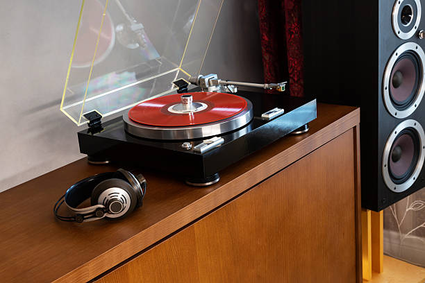 istock Vintage Stereo Turntable Record Player With Red Colored Disk, Headphones and Silver Weight Clamp, Wooden Console Cadenza, Black Loudspeaker 2218929042