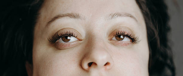 istock Open brown eyes of a woman with eyelash extensions. 2218929515