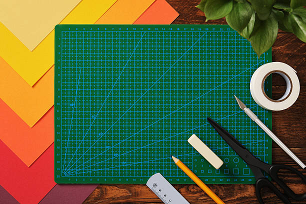 istock Banner with crafting tools. Neatly arranged sheets of colored paper, green cutting mat, scissors, craft knife, pencil, ruler. Wooden background, space for your text. 2218929537
