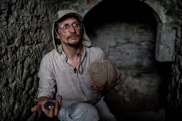 istock Explorer Examining Artifact in an Ancient Stone Tunnel During a Historical Expedition 2218936912