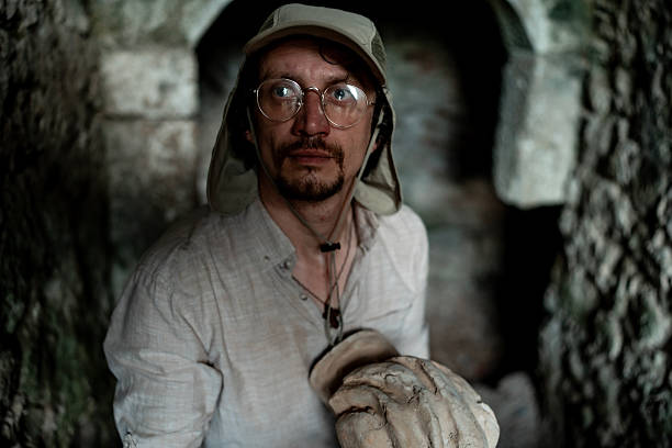 istock Explorer with Glasses Holding Artifact in Stone Archaeological Site 2218936915