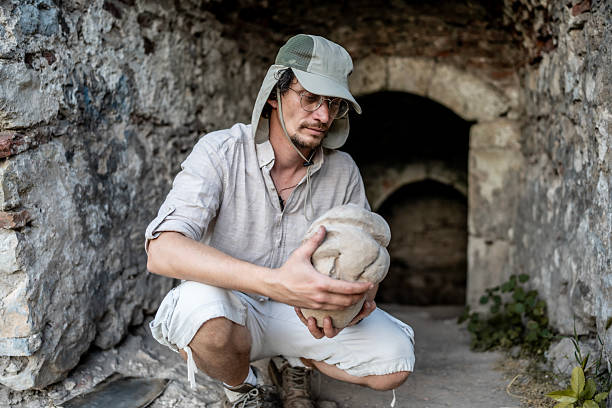 istock Archaeologist Examines Ancient Artifact in a Historic Stone Chamber 2218937672