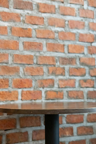 Wooden table next to the brick wall