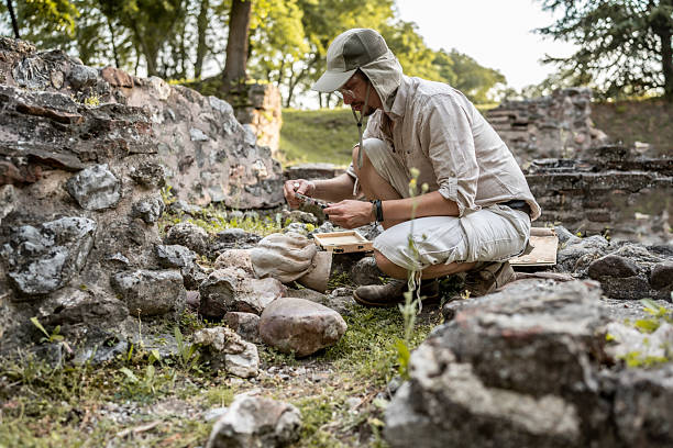 A dedicated archaeologist carefully examines remnants of ancient ruins at a historic excavation site, showcasing the meticulous process of uncovering and preserving historical artifacts in a natural and immersive outdoor environment.