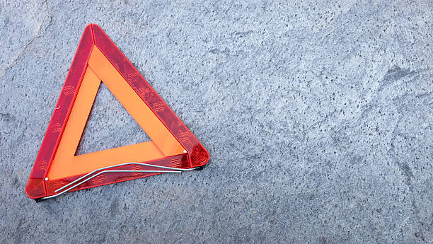 istock Warning red triangle signaling vehicle trouble on dark road surface 2218938693