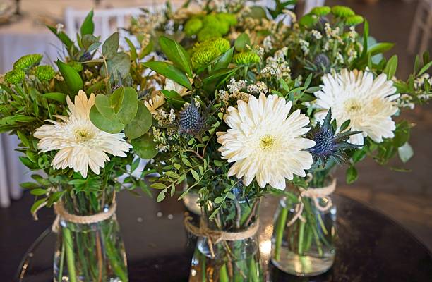 istock White gerbera daisies, eucalyptus, blue thistle forming elegant wedding centerpiece with soft, sophisticated botanical composition 2218939357