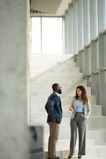 istock Business colleagues discussing on stairs in modern office 2218948053