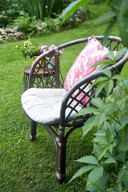 istock A charming garden nook featuring wicker chairs and tables surrounded by blooming annual flowers in soft pink hues. The scene evokes relaxation, outdoor comfort, and delicate floral beauty in a serene garden setting 2218949161