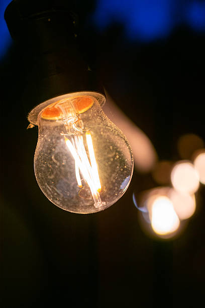 istock Light bulb is lit up in the dark. The light is warm and inviting. The bulb is glowing with a soft, yellow light. 2218952640