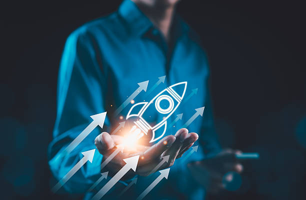 istock Business growth concept. Businessman presenting glowing rocket icon symbolizing startup success and growth acceleration. Rising earnings, increasing financial profits, Wealth fast, startup launch, 2218954743