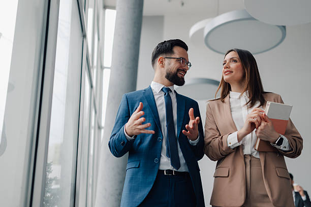 istock Businesspeople discussing while walking in office corridor 2218957690