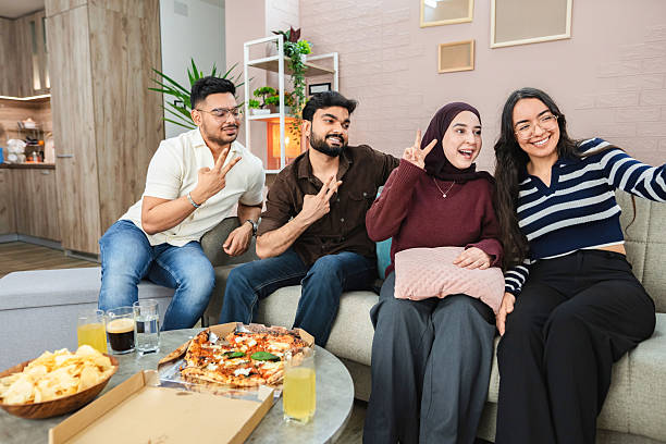 istock Group of friends taking a selfie while eating pizza at home 2218959618