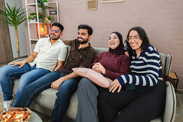 istock Four friends laughing and watching tv at home 2218959704