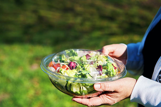 istock Eating Mixed Salad Bowl Packed in a Plastic Box Outside 2218959853