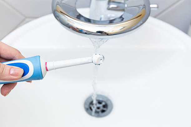 istock Cleaning toothbrush under running tap in tidy bathroom 2218961994