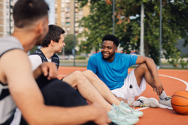istock Basketball players resting and chatting on court after training 2218964150