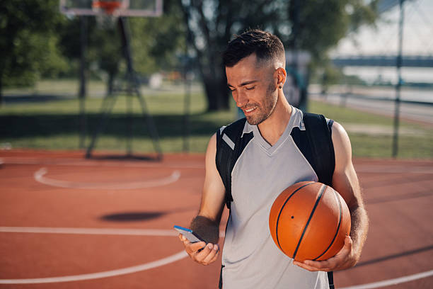 istock Basketball player checking his phone on the court after training 2218964183