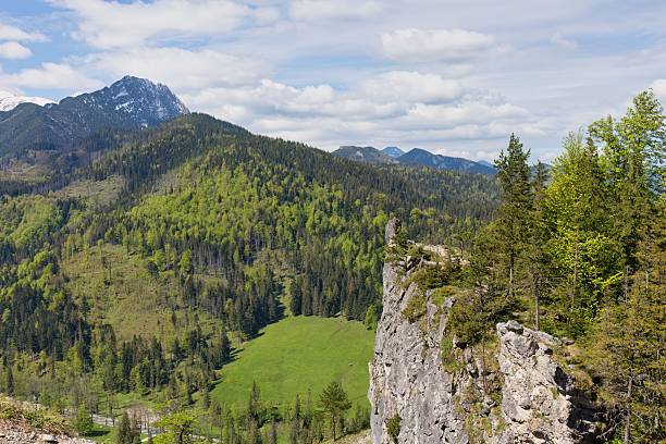 istock A mountain landscape features lush green hills and forests under a partly cloudy sky. 2218964836