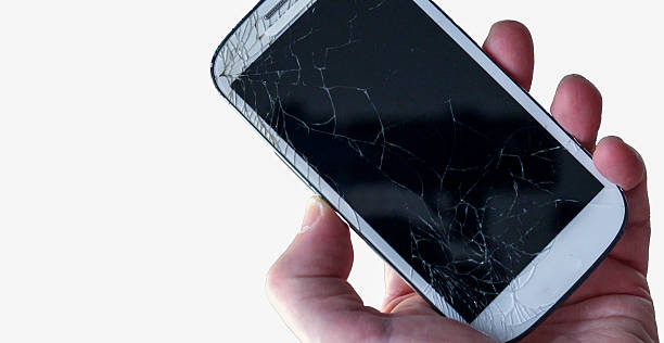 istock Hand holding a broken smartphone with a cracked screen on white background 2218965332