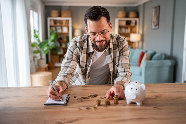 istock Man managing home finances and stacking coins at home 2218966424