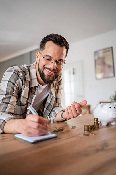 istock Young man managing home finances and counting savings 2218966476