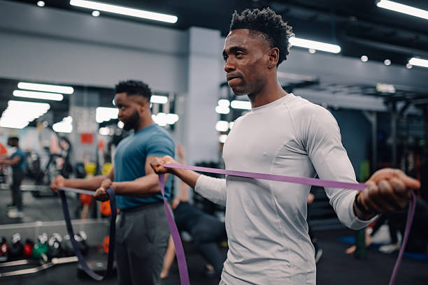 istock Determined black men performing resistance band exercises in gym 2218966825