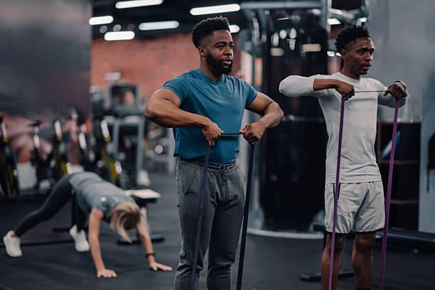 istock Two young men exercising with resistance bands in the gym 2218966827
