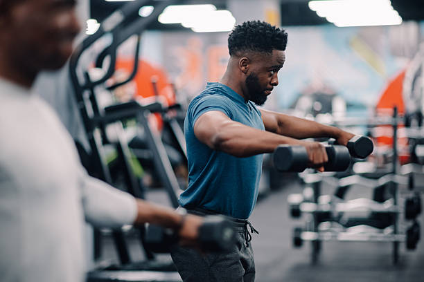 istock Determined black man lifting dumbbells in gym for strength training 2218966863