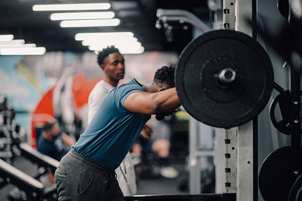 istock Determined young man lifting weights in modern gym 2218966898