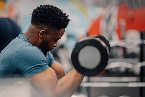 istock Determined bodybuilder lifting dumbbell in modern gym 2218966915
