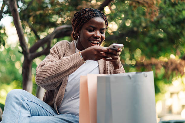 istock Young woman using smartphone after shopping spree 2218967145