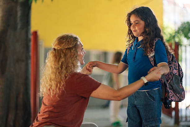 istock Mother holding hands with her elementary age daughter after school 2218967492