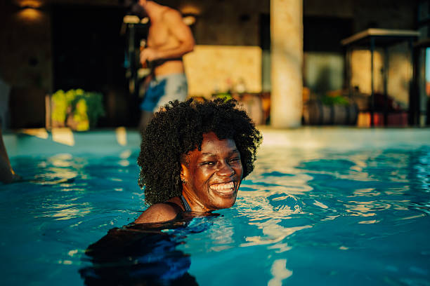 istock Joyful woman swimming in sunlit pool 2218970509