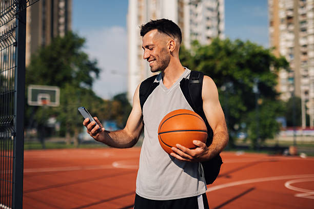istock Basketball player using smartphone on outdoor court 2218970853
