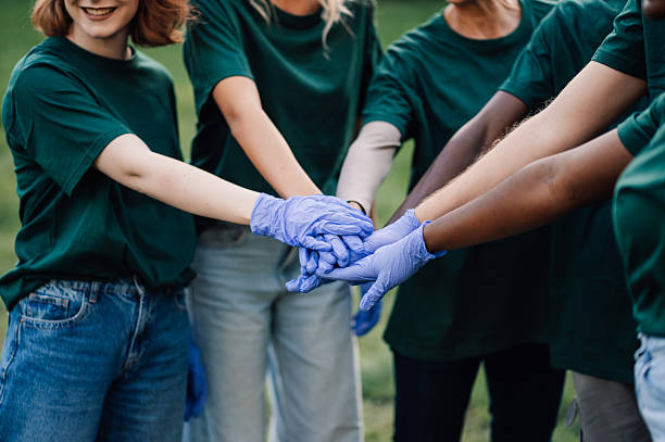istock Volunteers wearing gloves joining hands for teamwork 2218970881