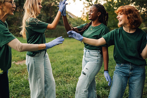 istock Volunteers giving high five during cleanup event in a park 2218971073