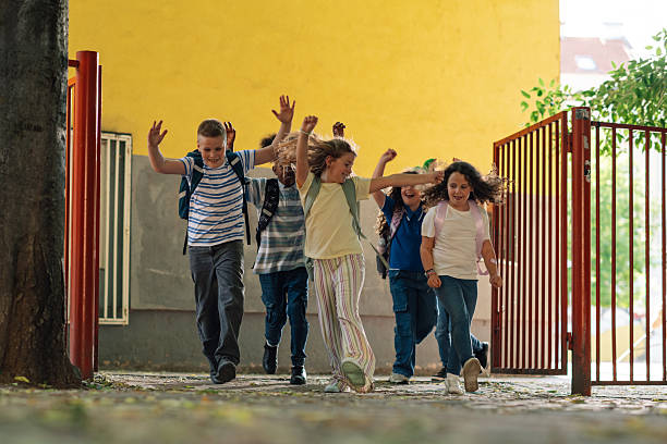 istock Cheerful students running out of school 2218971232