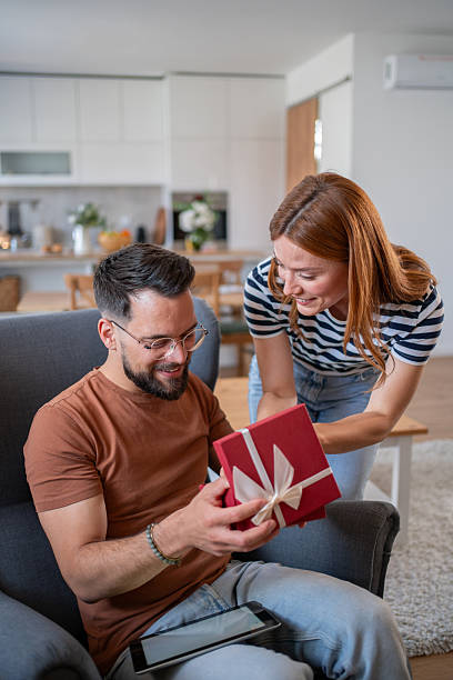istock Happy man receiving a gift from his girlfriend at home 2218971430