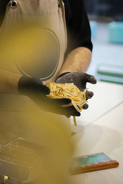 istock Freshly Made Fettuccine Pasta Held in Hands 2218979362