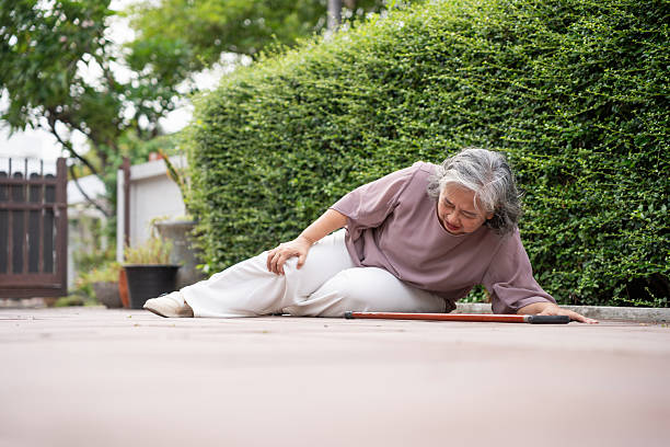 istock Senior Asian Woman Falling Down Outdoors Due to Accident or Weakness, Accidental Fall of a Mature Woman on a Paved Path, Elderly Woman Collapses While Walking, Needing Assistance 2218979500